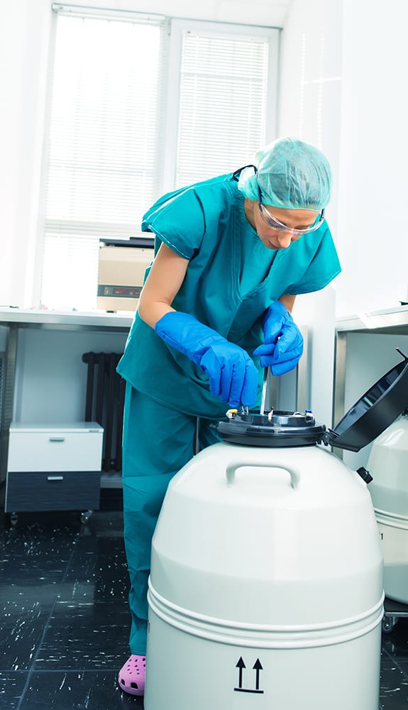 A fertility doctor freezing egg cells and sperm in a tank with liquid nitrogen