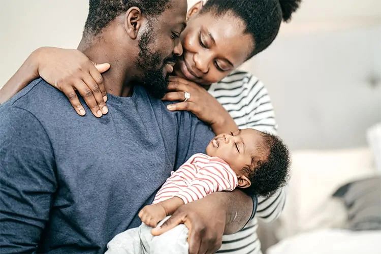 A couple with their baby after having experienced fertility problems