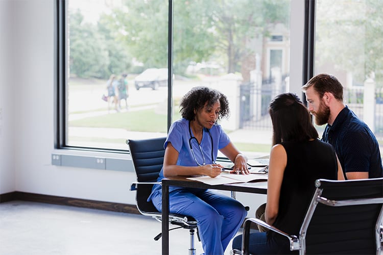 Embryologist talks with a couple after an embryo transfer