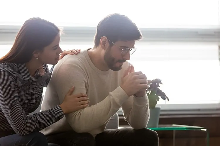 A man getting comforted after baby loss