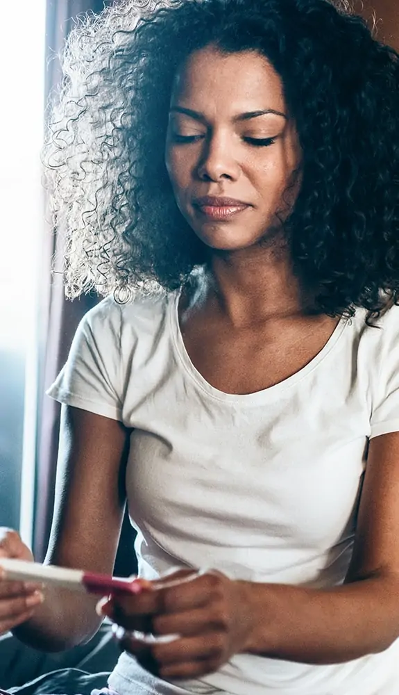 Woman having fibroids and looking at pregnancy test